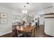 Dining room with wood table and view into living room and bright kitchen at 2654 Derbyshire Rd, Maitland, FL 32751