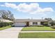 Charming single-story home featuring a well-manicured lawn and a freshly painted white brick facade on a sunny day at 2654 Derbyshire Rd, Maitland, FL 32751