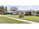 Charming single-story home featuring a well-manicured lawn and a freshly painted white brick facade on a sunny day at 2654 Derbyshire Rd, Maitland, FL 32751