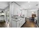 Modern kitchen with white cabinets, marble countertops, and stainless steel appliances and hardwood floors at 2654 Derbyshire Rd, Maitland, FL 32751