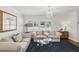 Bright living room with large windows, elegant chandeliers, and comfortable, neutral furniture at 2654 Derbyshire Rd, Maitland, FL 32751