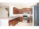 Well-lit kitchen with stainless steel appliances, granite countertops, and dark wood cabinets at 2851 Sunstone Dr # 2851, Kissimmee, FL 34758