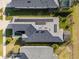 Birds-eye view showcases roof-mounted solar panels, screened lanai, manicured landscaping, and a well-kept lawn at 2941 Marlberry Ln, Clermont, FL 34714