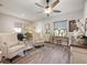 Cozy living room featuring neutral tones, wood-look flooring and a ceiling fan at 2941 Marlberry Ln, Clermont, FL 34714