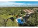 Overhead view of a community pool, lush trees, and residential buildings with a pond at 2962 Lucayan Harbour Cir # 102, Kissimmee, FL 34746