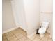 A bathroom with a shower featuring a white curtain, a toilet, and neutral tile flooring at 2962 Lucayan Harbour Cir # 102, Kissimmee, FL 34746