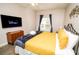 Cozy bedroom featuring a flat-screen TV, wood dresser, and window with blue curtains at 2962 Lucayan Harbour Cir # 102, Kissimmee, FL 34746