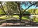 Scenic community view featuring a lake with fountain, walking path, mature trees, and seating for outdoor relaxation at 2962 Lucayan Harbour Cir # 102, Kissimmee, FL 34746