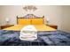 A bedroom with a yellow quilted bedspread, plush pillows, and coordinating wooden nightstands at 2962 Lucayan Harbour Cir # 102, Kissimmee, FL 34746