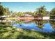 Picturesque view of a tranquil pond reflecting lush landscaping and clear blue skies at 2962 Lucayan Harbour Cir # 102, Kissimmee, FL 34746