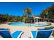 A resort style pool featuring palm trees, lounge chairs, and blue skies at 2962 Lucayan Harbour Cir # 102, Kissimmee, FL 34746