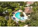Overhead view of a community pool area surrounded by lounge chairs, a pond, and landscaping at 2962 Lucayan Harbour Cir # 102, Kissimmee, FL 34746