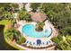 Aerial view of a community pool with seating, lush landscaping, and a nearby building at 2962 Lucayan Harbour Cir # 102, Kissimmee, FL 34746