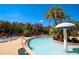 Exterior view of the community pool with palm trees, umbrellas, and lounge chairs at 2962 Lucayan Harbour Cir # 102, Kissimmee, FL 34746