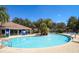Community pool with a clubhouse, palm trees, and lounge chairs at 2962 Lucayan Harbour Cir # 102, Kissimmee, FL 34746