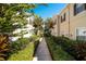 Serene community walkway framed by lush greenery and tropical plants creates a welcoming and peaceful ambiance at 2962 Lucayan Harbour Cir # 102, Kissimmee, FL 34746