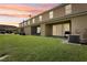 Backyard view of townhome with covered patio, sliding doors, and green lawn at 3008 Thornton Dr, Kissimmee, FL 34741