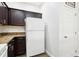 Kitchen with dark wood cabinets, granite countertops, and white refrigerator at 3008 Thornton Dr, Kissimmee, FL 34741