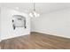 Open-concept living space with hardwood floors, decorative light fixture, and passthrough to the kitchen at 3008 Thornton Dr, Kissimmee, FL 34741