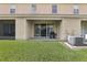 Covered patio features sliding glass doors, storage, and a grill in the backyard at 3008 Thornton Dr, Kissimmee, FL 34741