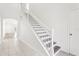 Well-lit staircase with white railings and wood steps at 3008 Thornton Dr, Kissimmee, FL 34741