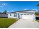 Charming one story home featuring an attached two car garage and manicured lawn at 301 Bowfin Dr, Kissimmee, FL 34759