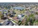 Aerial view featuring homes near a pond showing screened pools, fenced yards, and neighborhood streets at 3123 Fairfield Dr, Kissimmee, FL 34743
