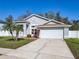 Well-maintained home featuring a two-car garage, complemented by a green lawn and landscaping at 3123 Fairfield Dr, Kissimmee, FL 34743