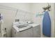 Laundry room boasts modern washing machine, dryer, shelving and ironing board at 3384 Fallbrook Dr, Poinciana, FL 34759