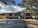 Charming single-story home featuring a well-maintained yard and black asphalt driveway at 34517 Laralack Ave, Leesburg, FL 34788