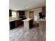 Well-lit kitchen with modern island, stainless steel appliances, and wood-look flooring at 34517 Laralack Ave, Leesburg, FL 34788