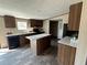 The kitchen area features an island, modern appliances, granite counters and wood-look floors at 34517 Laralack Ave, Leesburg, FL 34788