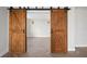 Rustic barn doors on a track system offer a unique and stylish transition to the adjacent room with herringbone floors at 400 E Colonial Dr # 1504, Orlando, FL 32803