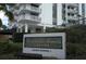 A sign for Park Lake Towers Condominium with visitor parking under an awning with plants surrounding the sign at 400 E Colonial Dr # 1504, Orlando, FL 32803