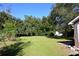 A expansive backyard features green grass and mature trees, offering privacy at 4235 W Vista Ct, Kissimmee, FL 34746