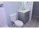 This half bathroom features tiled walls, a toilet, and a gray vanity at 4235 W Vista Ct, Kissimmee, FL 34746