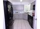 Well-lit kitchen features gray cabinets, black appliances, and tiled flooring at 4235 W Vista Ct, Kissimmee, FL 34746