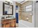 Bathroom with updated vanity, bathtub, and tiled wall with mosaic accents at 4884 Meadow Dr, St Cloud, FL 34772