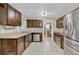 Modern kitchen with stainless steel appliances and tiled floors, adjacent laundry room at 4884 Meadow Dr, St Cloud, FL 34772