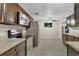 Modern kitchen with stainless steel appliances and tiled floors, adjacent dining area at 4884 Meadow Dr, St Cloud, FL 34772