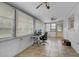 Bright sunroom with tile floor, windows, ceiling fans, and a workspace area at 4884 Meadow Dr, St Cloud, FL 34772