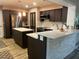 Modern kitchen featuring dark wood cabinets, stainless steel appliances, and an island with white countertop at 5019 Saint Germain Ave, Orlando, FL 32812