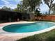 Inviting kidney-shaped pool with a pink deck, adjacent to a screened-in patio and fenced yard at 5019 Saint Germain Ave, Orlando, FL 32812