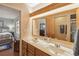 Bright bathroom featuring a double sink vanity, large mirror, and separate access to the bedroom and shower at 534 Minnow Ct, Kenansville, FL 34739