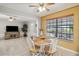 Light-filled dining area with a round table, white chairs, and views of the backyard at 534 Minnow Ct, Kenansville, FL 34739