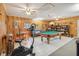 Spacious game room featuring a pool table, exercise equipment, and wood paneling at 534 Minnow Ct, Kenansville, FL 34739