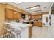 Well-lit kitchen features wood cabinets, tile backsplash, and a breakfast bar with seating at 534 Minnow Ct, Kenansville, FL 34739