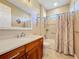 Bathroom featuring wood cabinets, a bathtub with shower, and an elegant mirror at 551 San Raphael St, Kissimmee, FL 34759