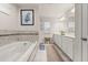 Bright bathroom featuring a soaking tub, tiled walls, and a double sink vanity with ample counter space at 5685 Surprise Lily Dr, Winter Garden, FL 34787