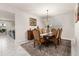 Elegant dining room with a wooden table, six upholstered chairs, and a decorative chandelier at 5685 Surprise Lily Dr, Winter Garden, FL 34787